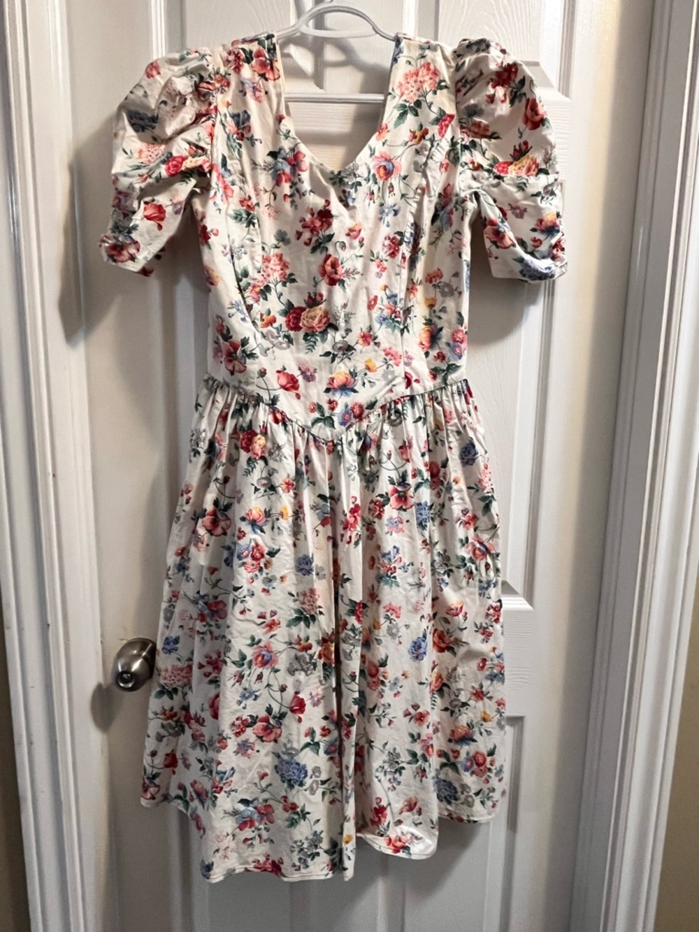 80’s vintage-style white floral dress featuring puffed sleeves and a V-neckline,